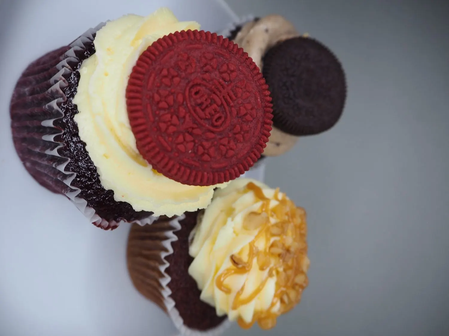 Iced cupcakes topped with whole Oreo biscuits.