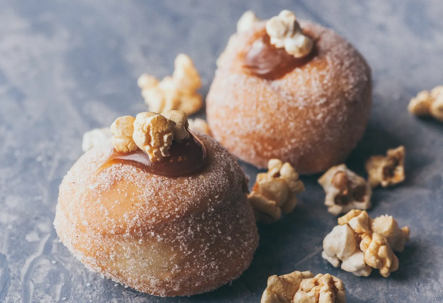 Caramel donuts topped with caramel popcorn.