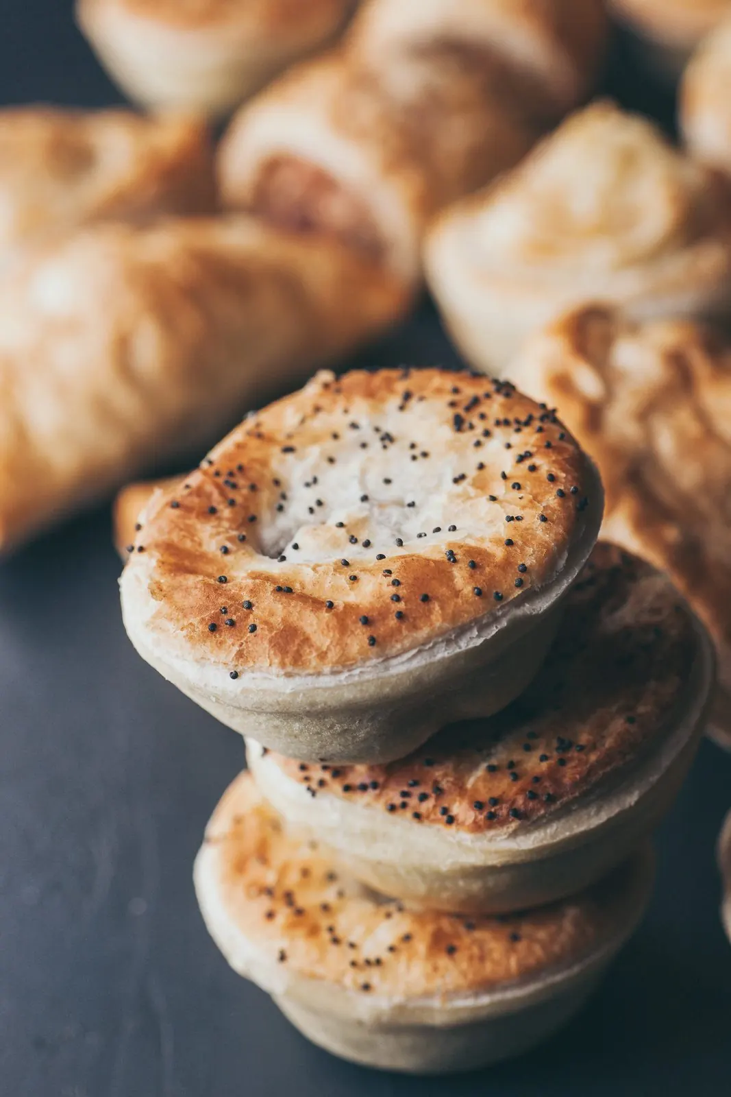 A stack of poppy seed topped pies.