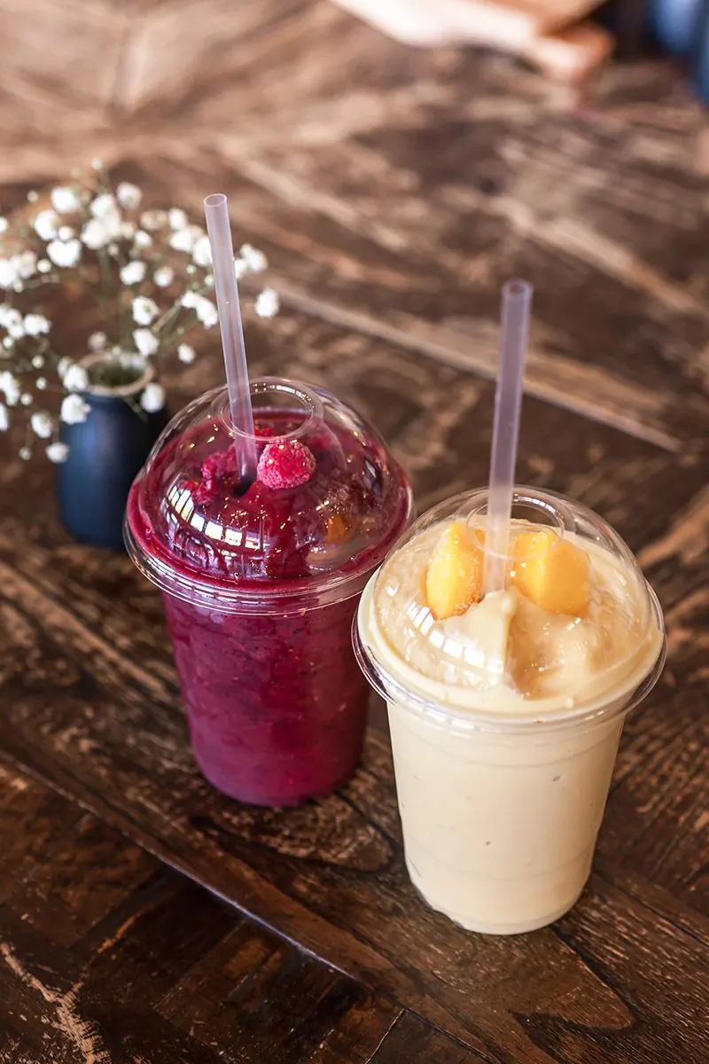Two smoothies in takeaway cups.