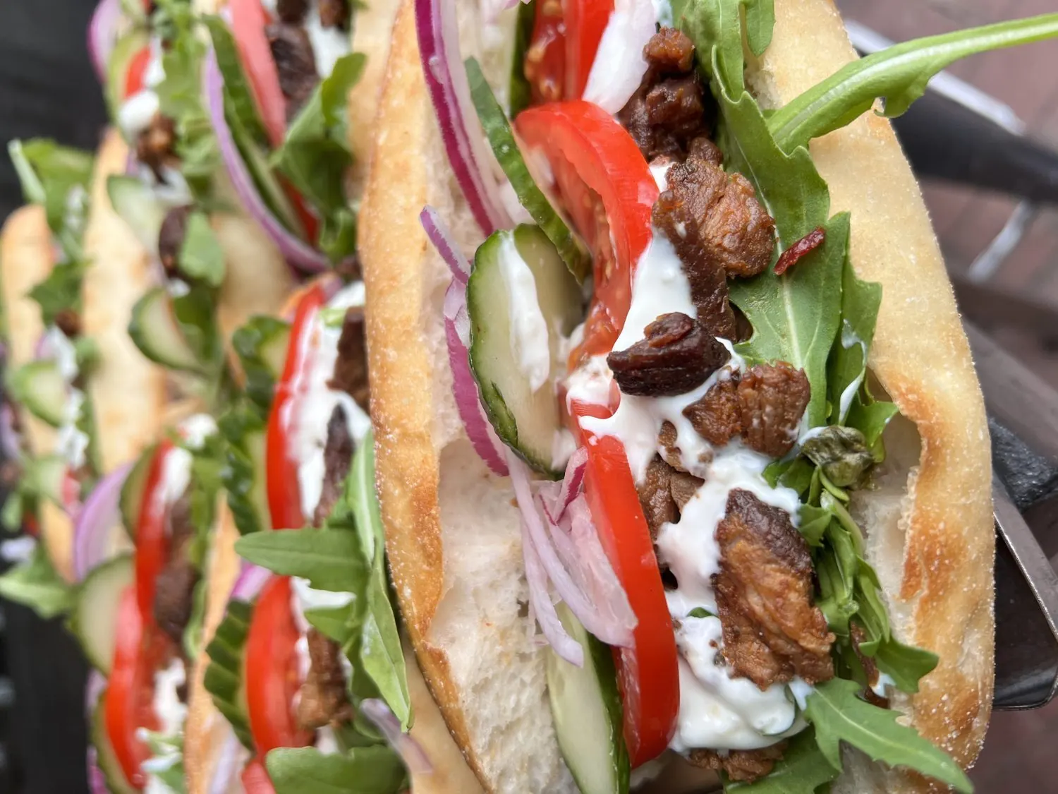 Close up of filled wraps with chicken, salad and dressing.